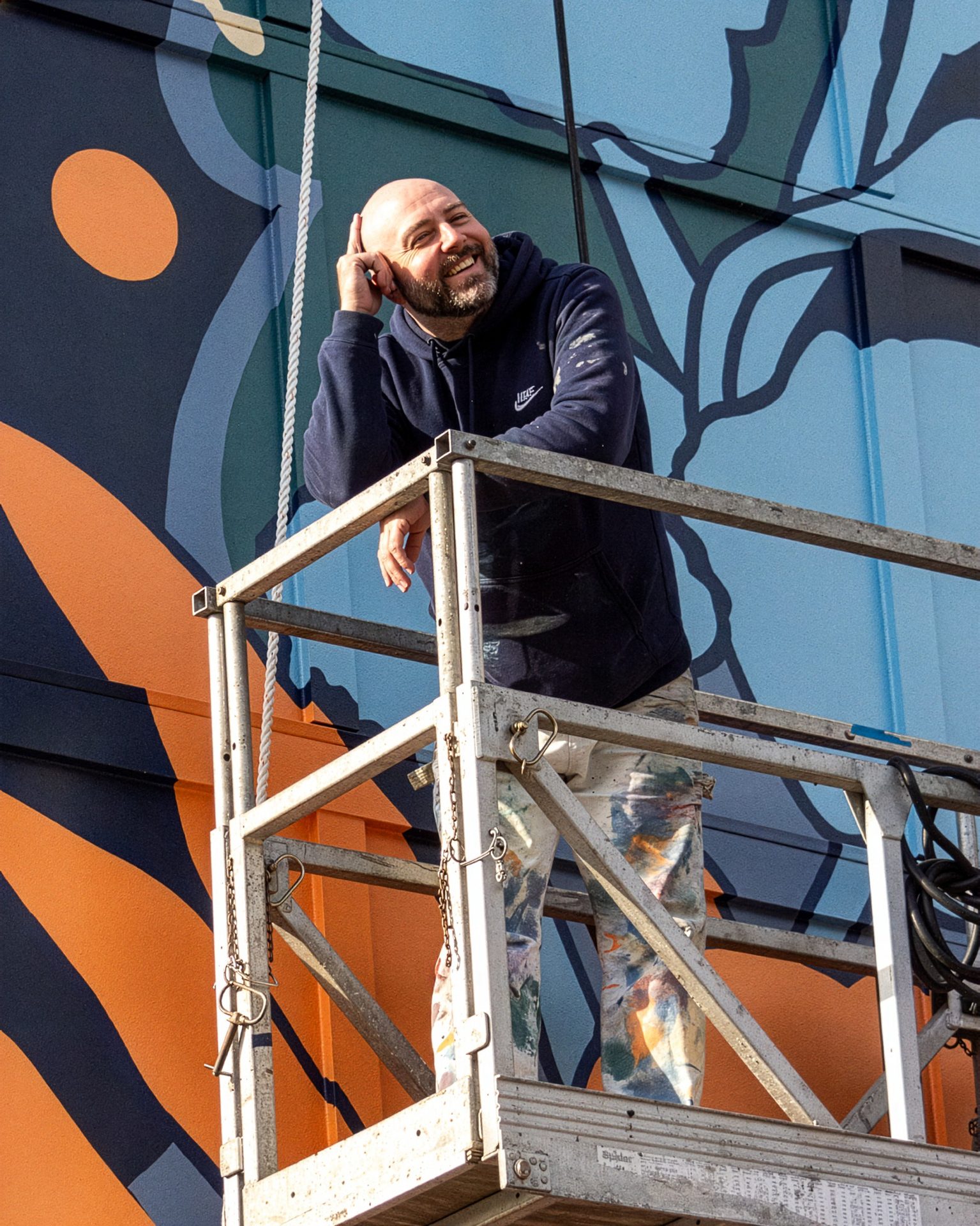Adam Stephenson painting the Homecoming mural in Decatur, Alabama