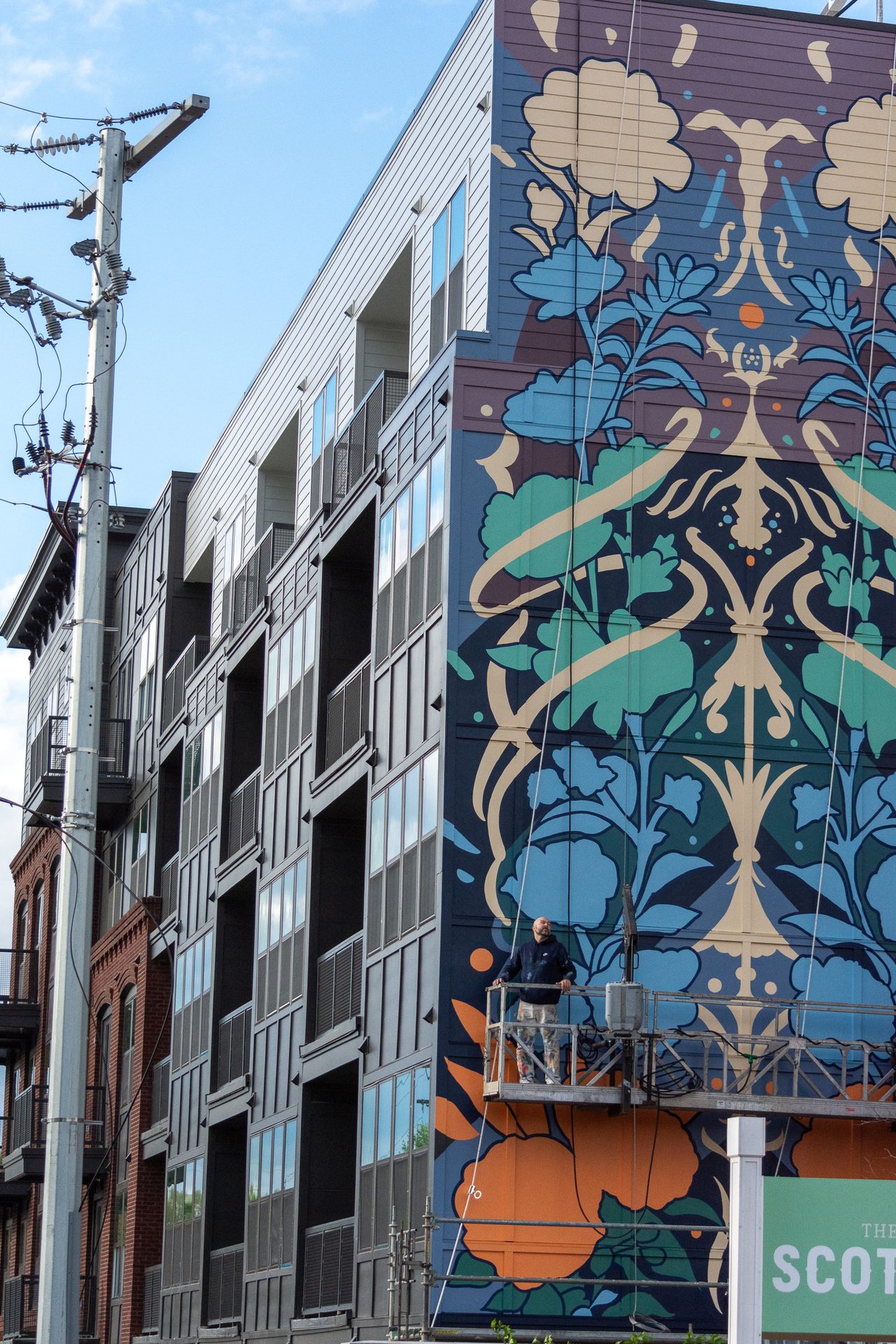 The Scottie mural with Adam Stephenson at the base for scale, multi-story commercial mural, Nashville, Tennessee, 2023