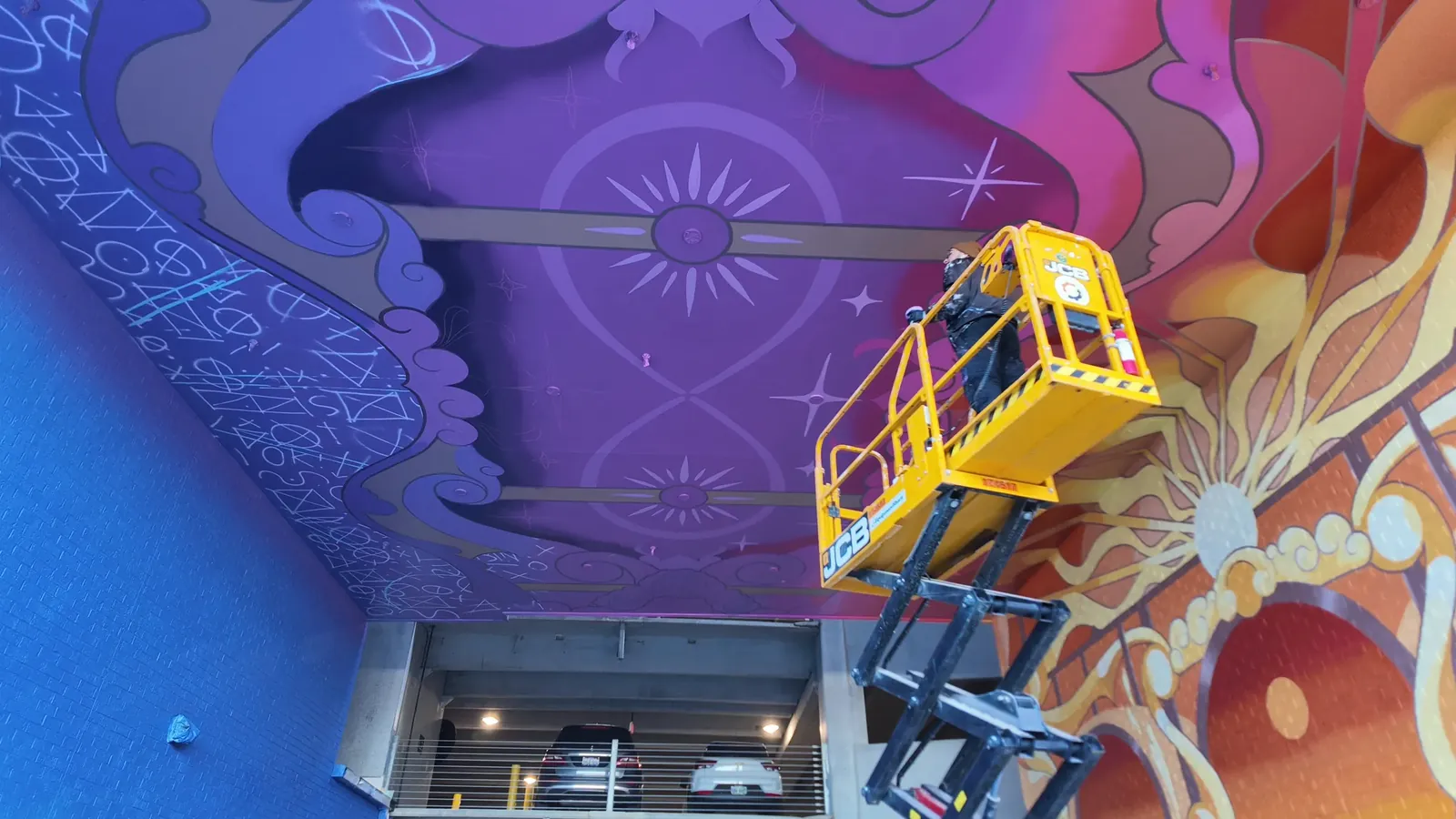 Drone view of the Hall of the Magician ceiling mid-paint, Adam Stephenson on a scissor lift adding stars, November 2025