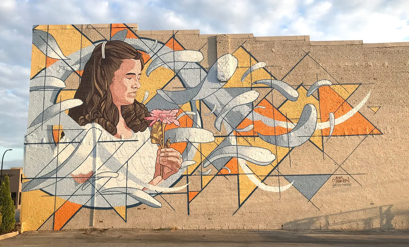 Homecoming — 40×70 ft mural by Adam Stephenson on a downtown building in Decatur, Alabama (2019), a figurative portrait holding a flower
